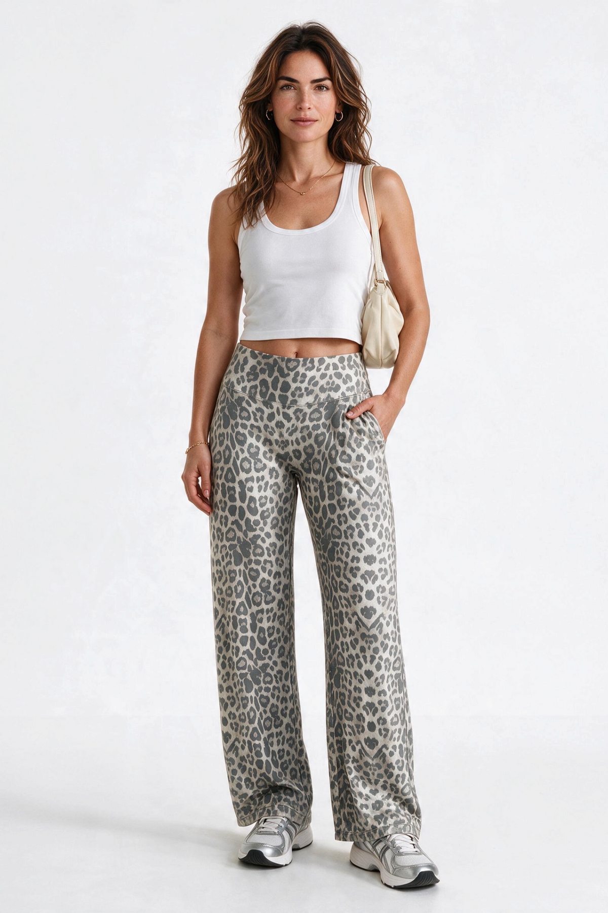 Baya Wear high-waisted wide leg yoga pants in a grey leopard print, paired with a white tank top and sneakers.