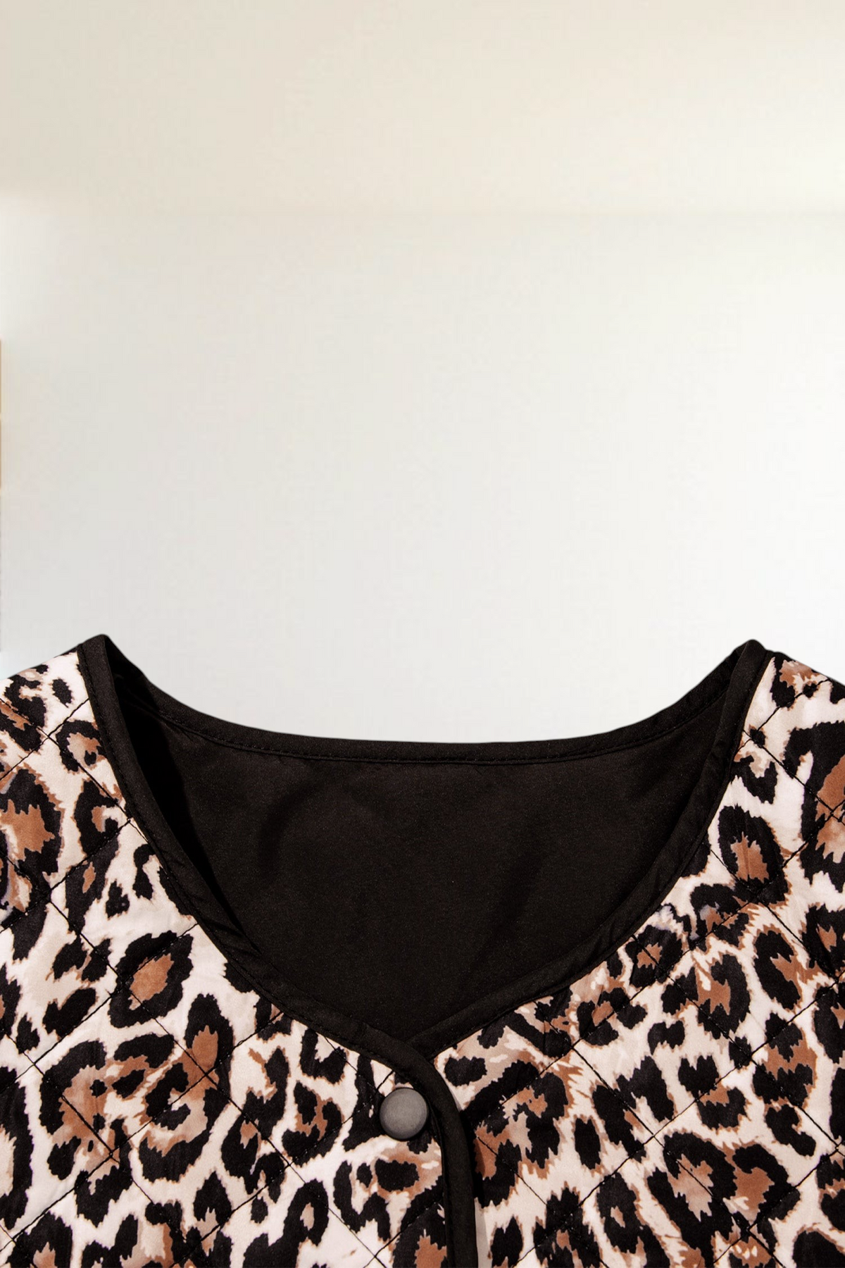 Baya Wear quilted jacket featuring a brown leopard print pattern with black trim and a button front closure.