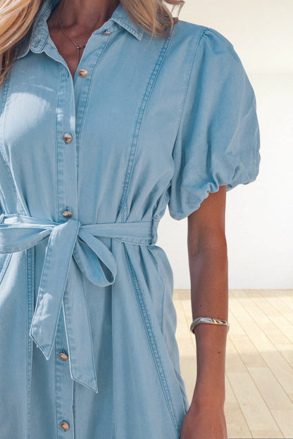 Baya Wear light blue denim midi dress with puff sleeves, button-down front, and a matching tie-waist belt.