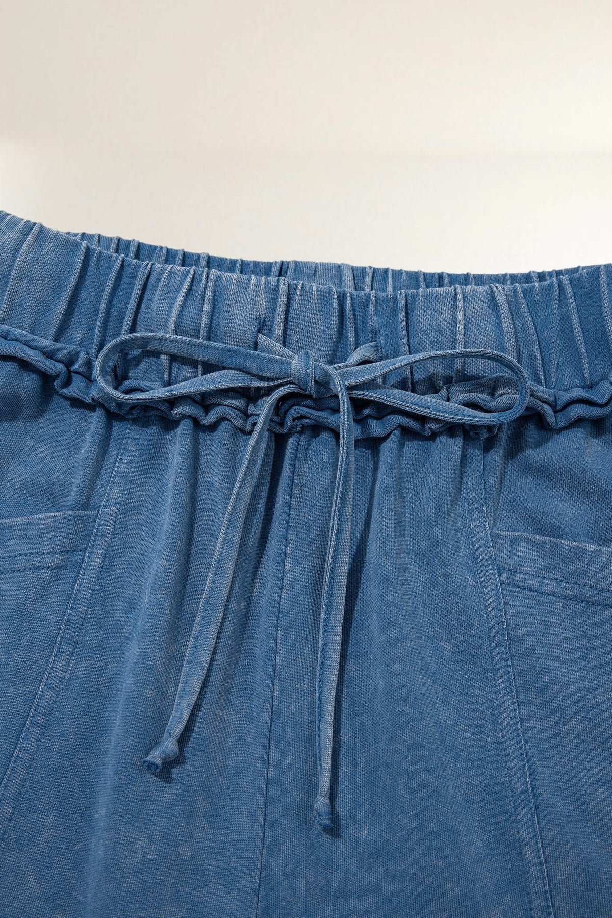 Baya Wear blue mineral wash lounge pants featuring a gathered drawstring waist and detailed seam stitching.