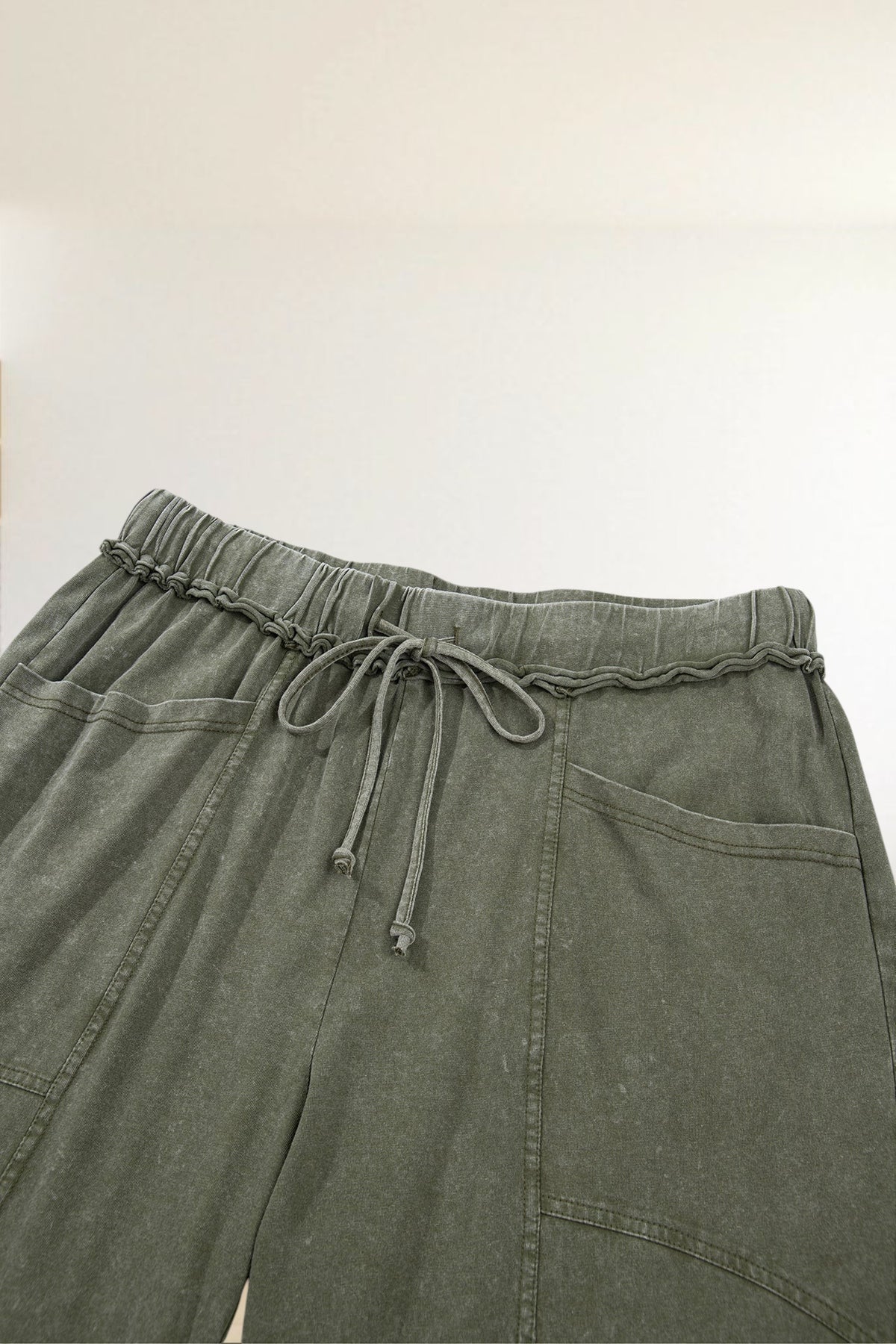 Baya Wear olive green mineral wash lounge pants with a drawstring waist, seam detailing, and side pockets.