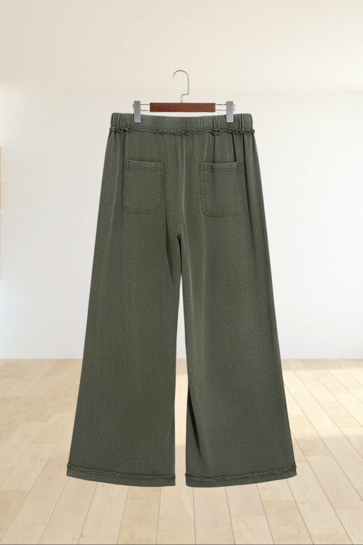 Baya Wear olive green mineral wash wide leg lounge pants with a drawstring waist and back pockets on a hanger