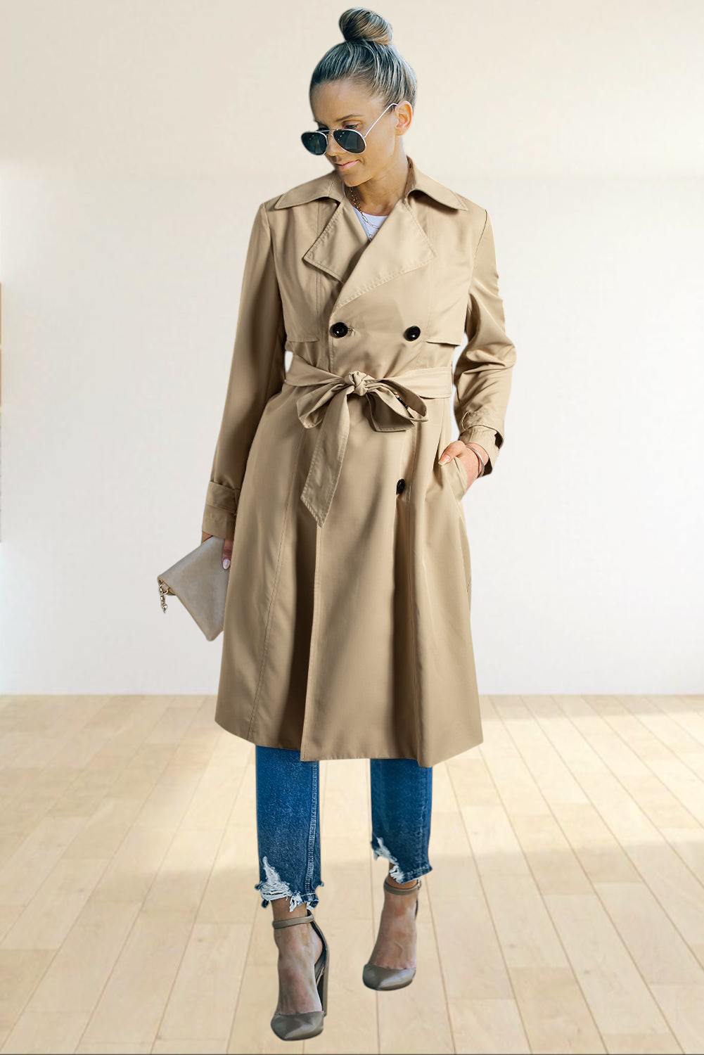 Baya Wear pale khaki double breasted trench coat with a waist-tie belt worn by a woman with jeans and heels