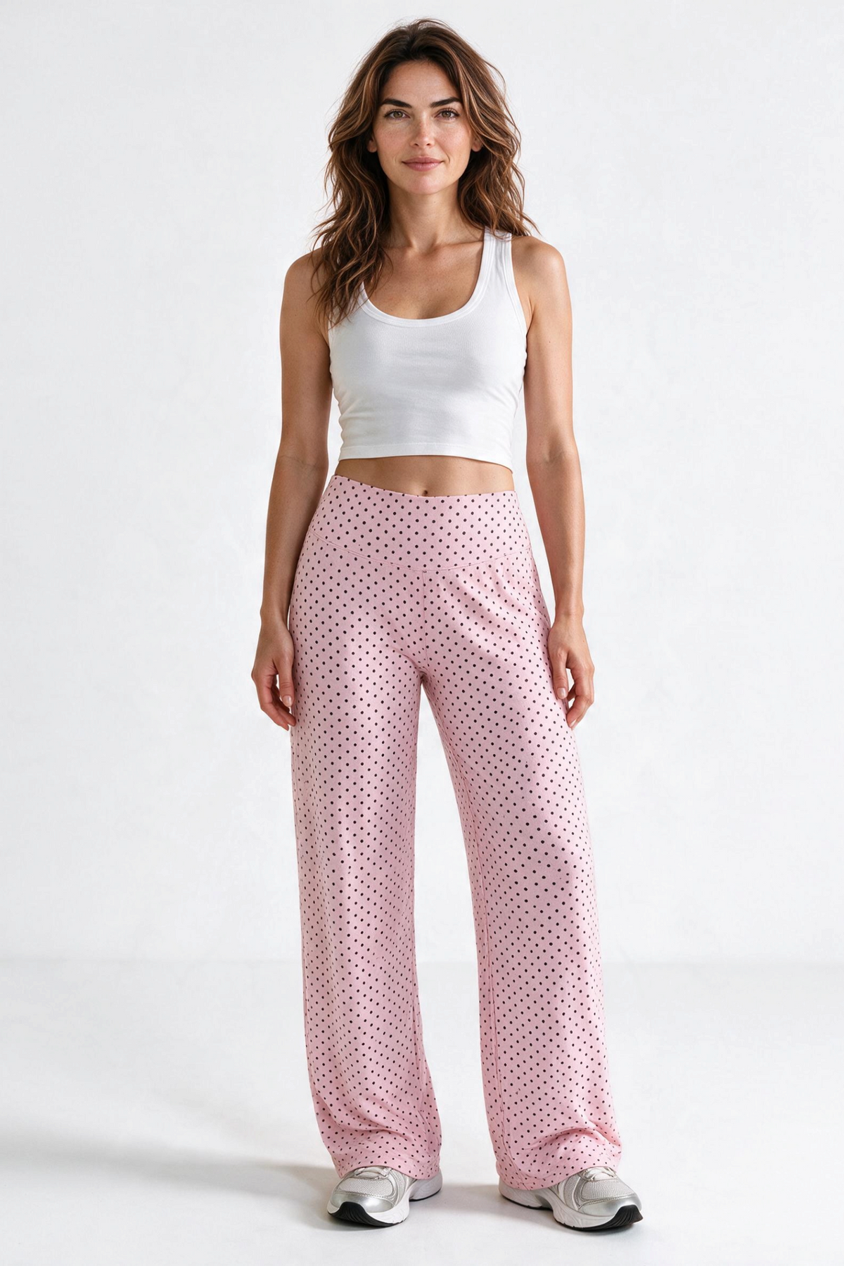 Baya Wear high-waisted wide leg yoga pants in light pink with black polka dots worn with a white tank top