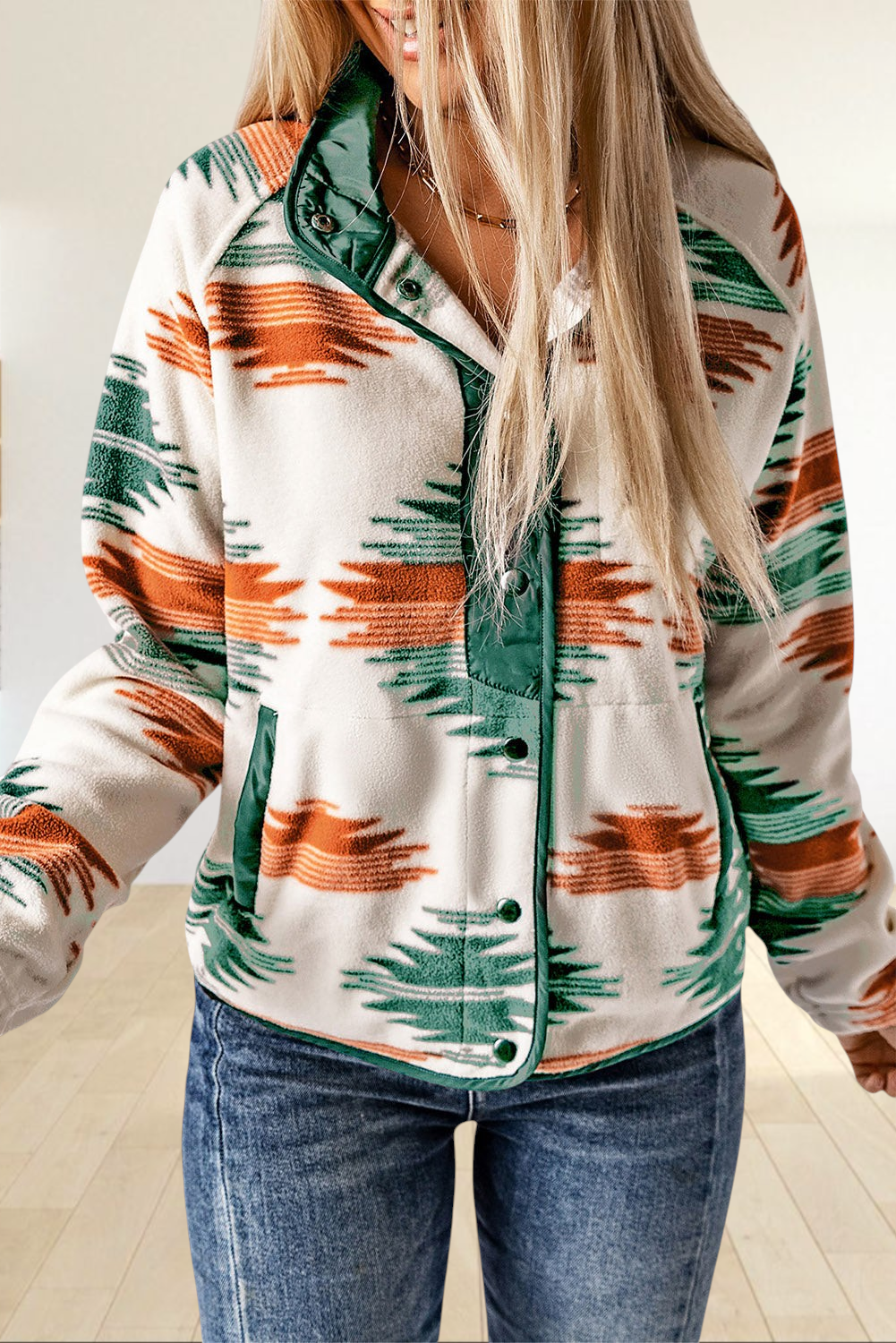 Baya Wear cream fleece jacket with orange and green geometric pattern, snap buttons, and forest green trim.