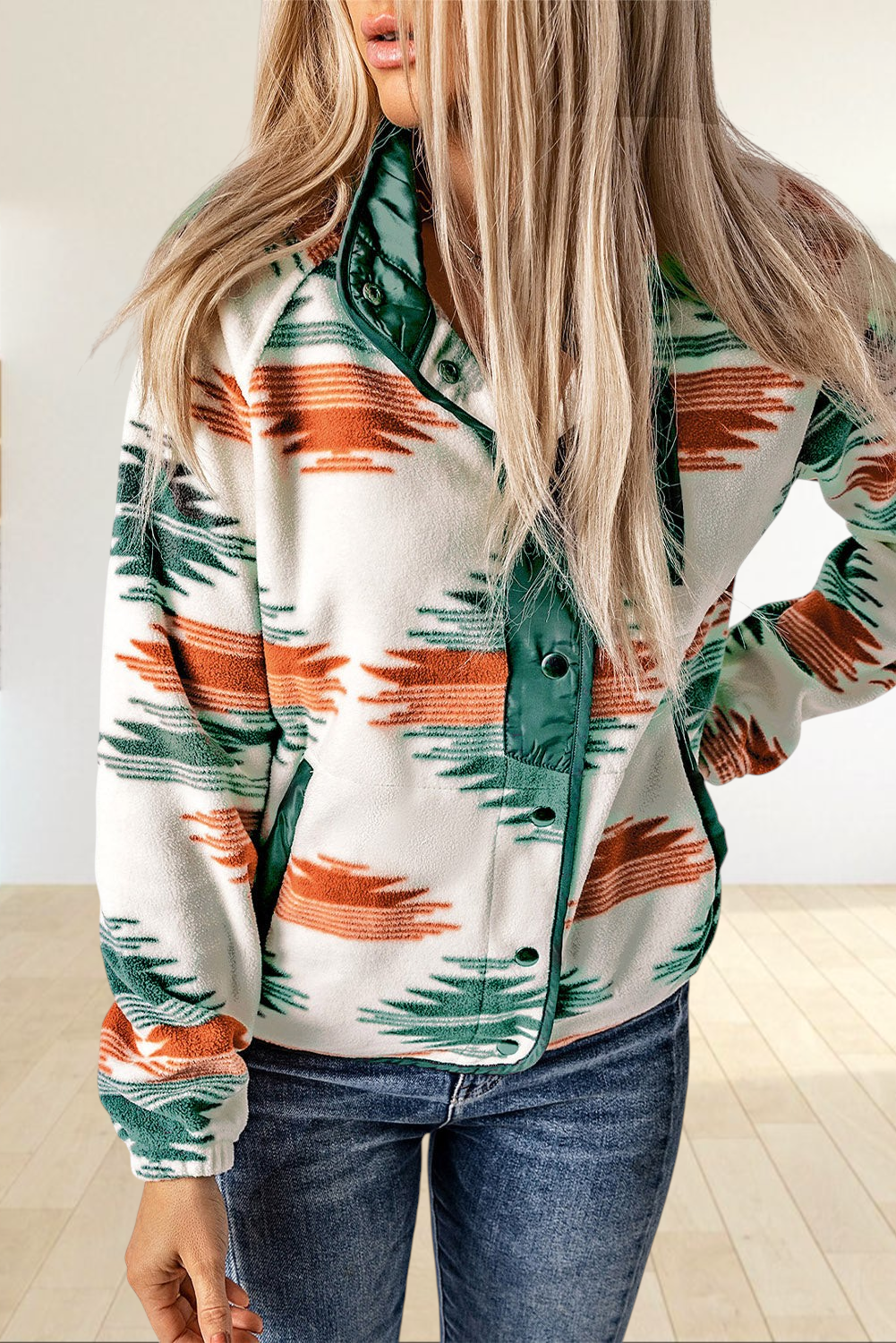 Baya Wear fleece jacket featuring a geometric pattern in orange and green on cream with snap buttons and green trim.