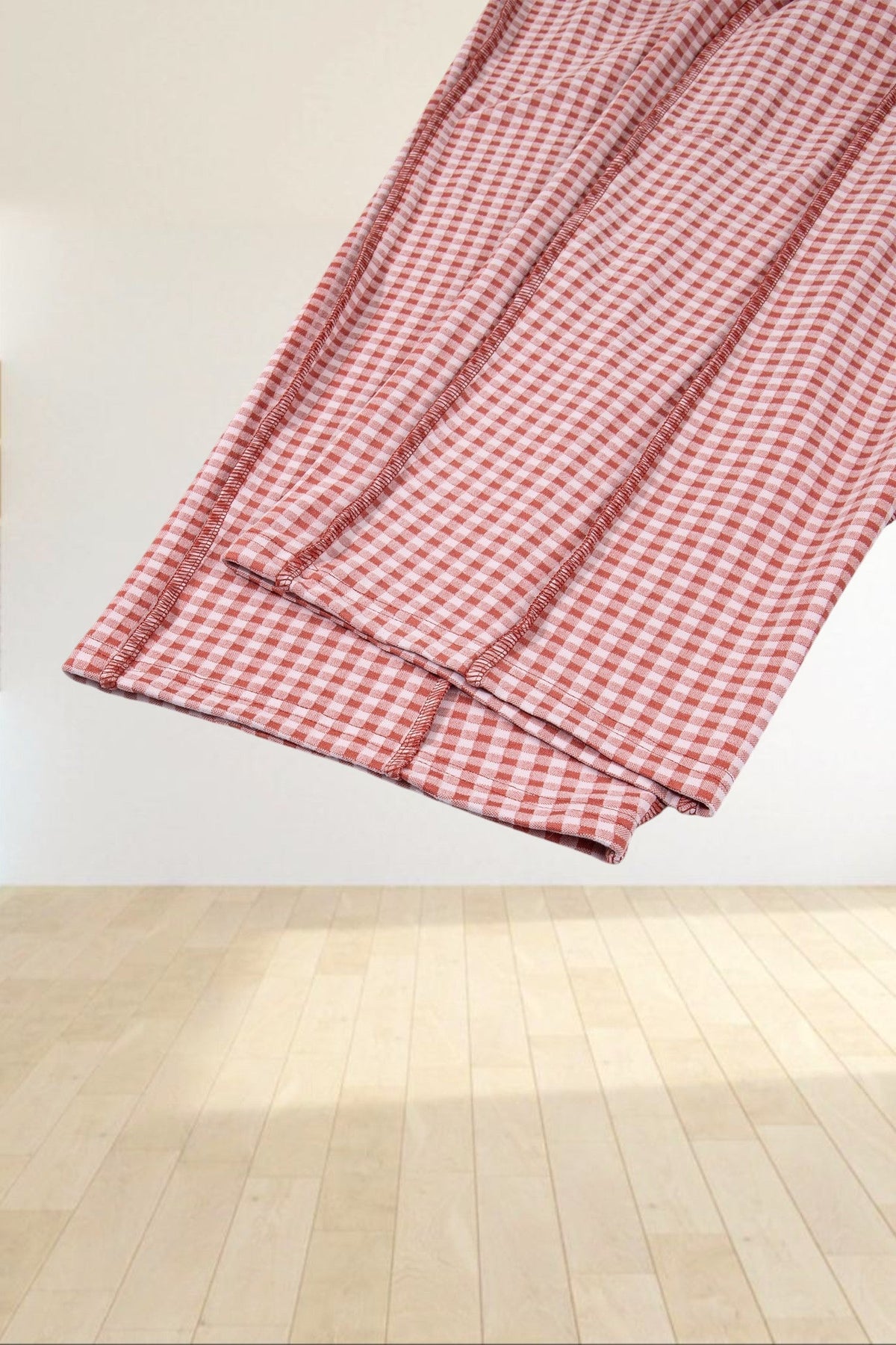 Baya Wear red and white gingham wide leg lounge pants featuring contrast stitching detail on a grey background