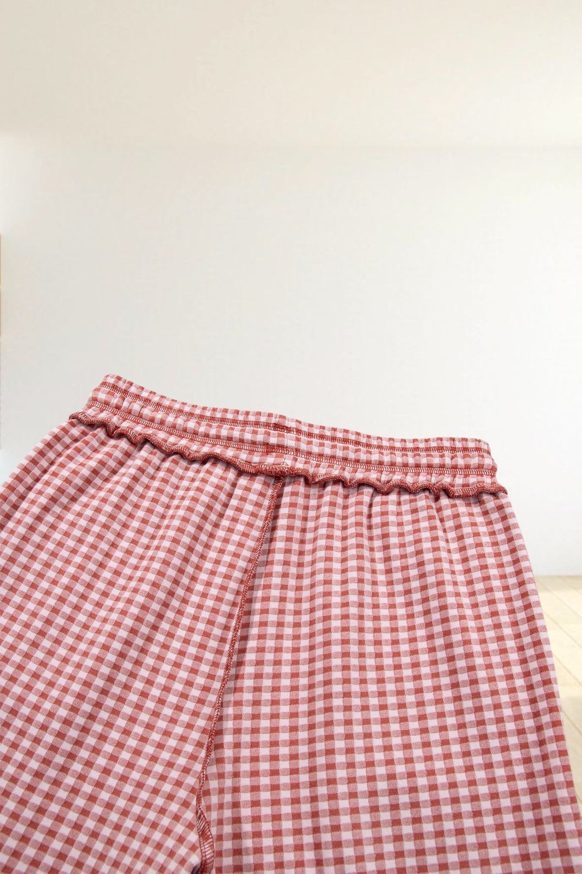 Baya Wear red and white gingham wide leg lounge pants with an elastic drawstring waistband and contrast stitching.