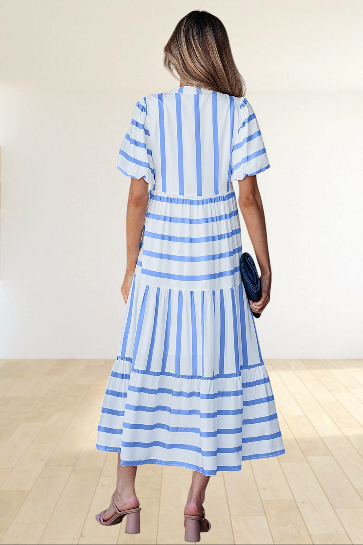 Baya Wear tiered midi dress in white and blue stripes with half sleeves, viewed from the back in a patio setting.