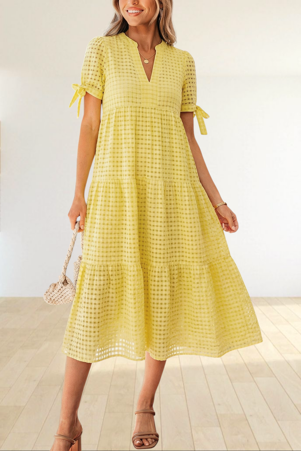 Baya Wear yellow textured gingham tiered midi dress with V-neck, short sleeves, and bow-tie details on a model.